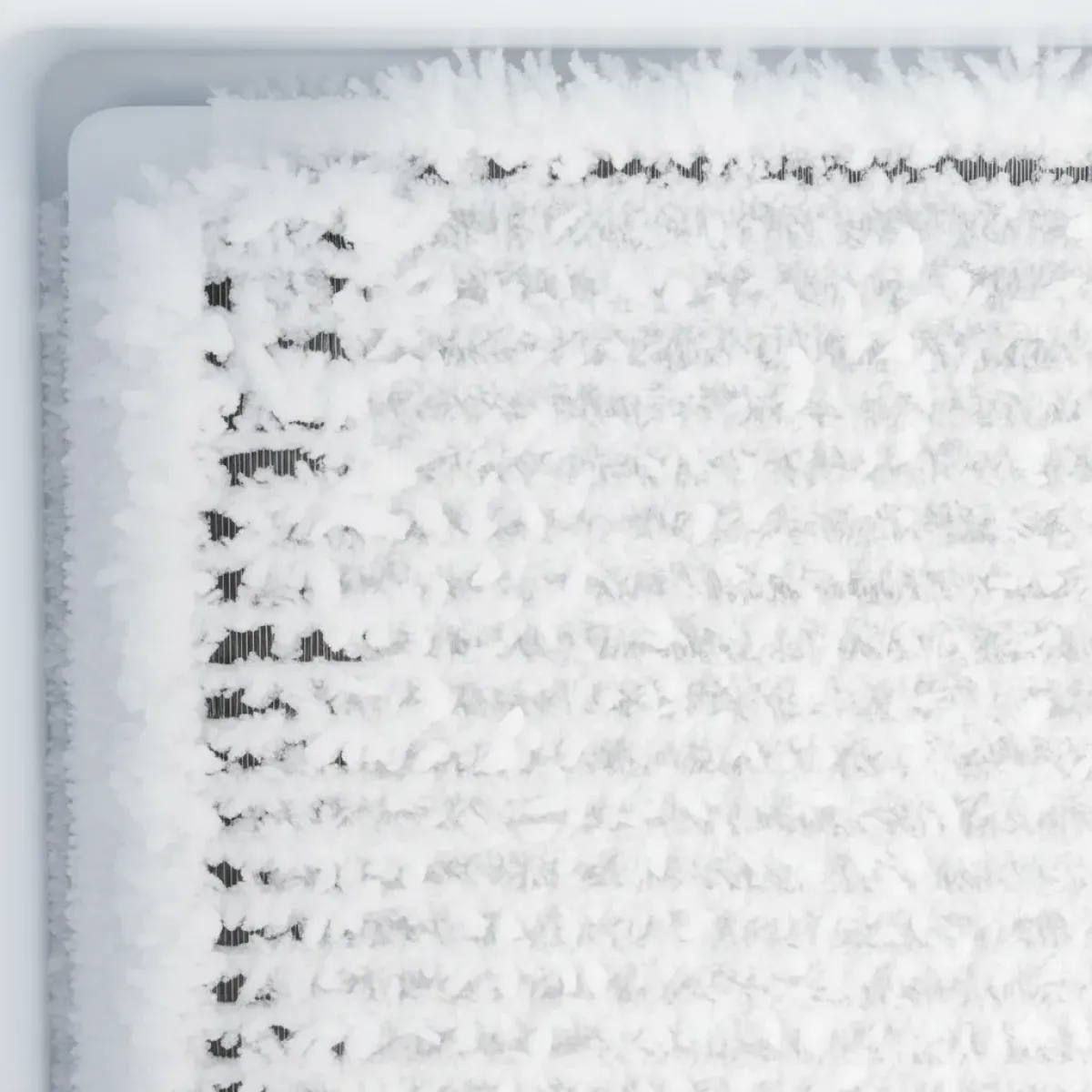 Buzdolabının altının soğutmama nedenini gösteren, buzla tamamen tıkanmış no-frost hava kanalları ve evaporatör petekleri.